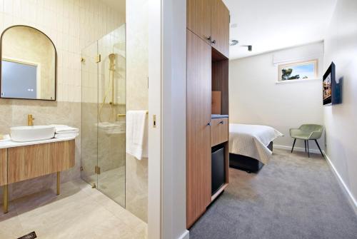 a bathroom with a shower and a sink and a mirror at The Tanunda Club Guest Suites in Tanunda
