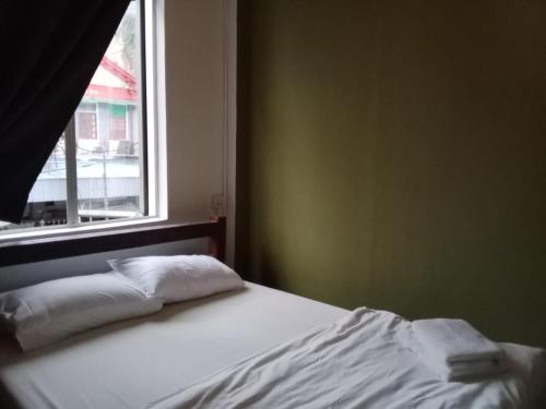 a bed with two pillows in a room with a window at The Manor by Mingle - FREE Breakfast with Poolside Access in Kuala Lumpur