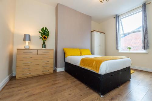 a bedroom with a bed and a dresser and a window at Cedar Room in Liverpool