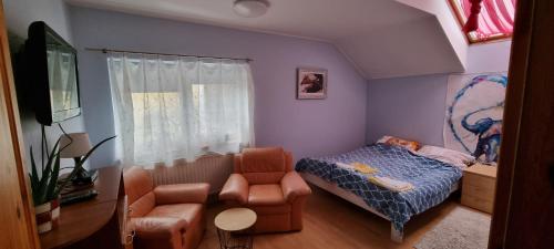 een kleine slaapkamer met een bed en een stoel bij Apartament w Komornikach in Komorniki
