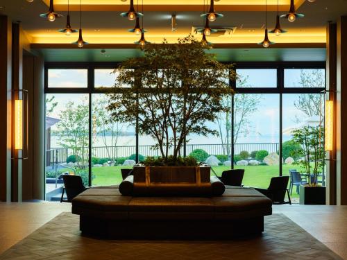a large room with a table with a tree in it at Grandvrio Hotel Beppuwan Wakura - ROUTE INN HOTELS - in Beppu