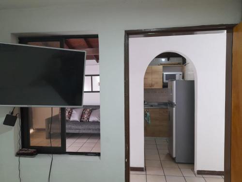 a living room with a television and a kitchen at Amoblado centro de la Moda in Itagüí