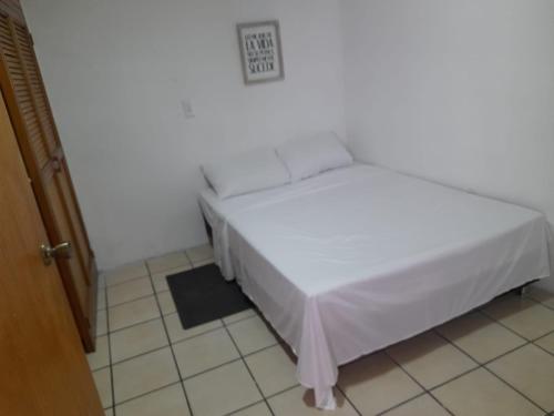 a bedroom with a white bed in a room at Amoblado centro de la Moda in Itagüí