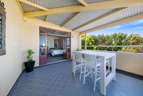 a patio with a table and chairs on a balcony at The Tanunda Club Guest Suites in Tanunda