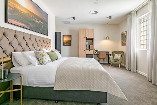 The Tanunda Club Guest Suites في تانوندا: غرفة نوم بسرير كبير ومكتب