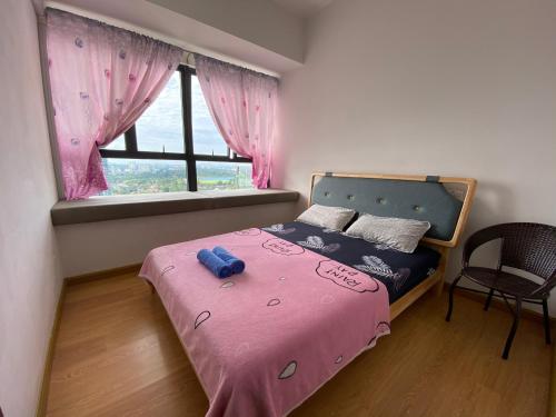 a bedroom with a pink bed with a window at Amazing Infinity Sea View Johor Bahru in Johor Bahru