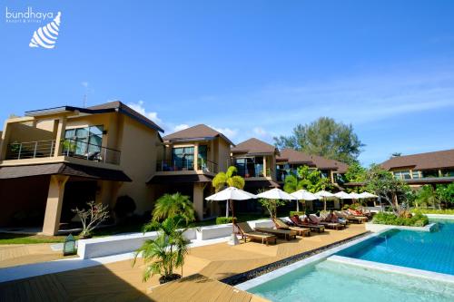 ein Resort mit einem Pool mit Stühlen und Sonnenschirmen in der Unterkunft Bundhaya Villas in Ko Lipe