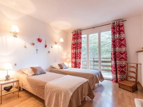 two beds in a room with a window at Appartement Le Monêtier-les-Bains, 3 pièces, 6 personnes - FR-1-330F-132 in Le Monêtier-les-Bains