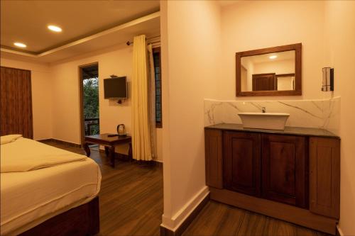 a bedroom with a sink and a mirror at Avadale Thekkady - Stag Groups Not Allowed in Thekkady