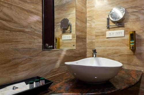 a bathroom with a white sink and a mirror at Hotel Prism - A Boutique Hotel in Jorhāt