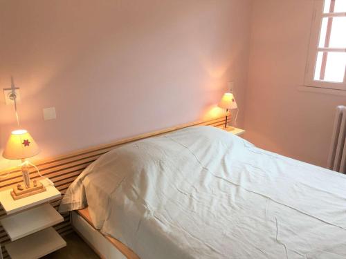 une chambre avec un lit et deux tables de nuit avec lampes dans l'établissement Appartement T2 pour 4 avec balcon, Wi-Fi gratuit, proche des pistes et équipements complets - FR-1-457-220, à Saint-Lary-Soulan