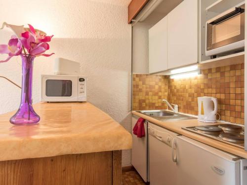 une cuisine avec un vase de fleurs sur un comptoir dans l'établissement Appartement cosy 6 pers. à Montgenèvre, balc. sud, ascenseur, proche pistes - FR-1-330D-28, à Montgenèvre