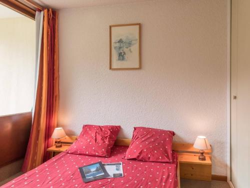 - une chambre avec un lit rouge et un livre dans l'établissement Appartement cosy 6 pers. à Montgenèvre, balc. sud, ascenseur, proche pistes - FR-1-330D-28, à Montgenèvre