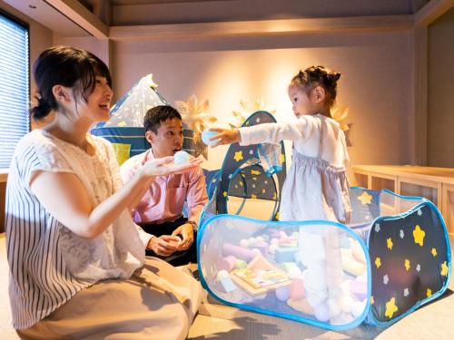 a woman and a child playing with a video game at Grandvrio Hotel Beppuwan Wakura - ROUTE INN HOTELS - in Beppu