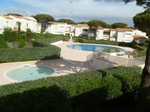 - une grande piscine dans une cour avec des maisons dans l'établissement T3 avec Terrasse, Piscine, Tennis et Parking Privé à 100m de la Plage - FR-1-607-1, au Cap d'Agde
