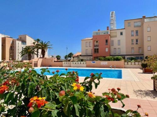 - une piscine fleurie devant certains bâtiments dans l'établissement Spacieux T3 avec piscine et parking près du port - FR-1-607-10, au Cap d'Agde