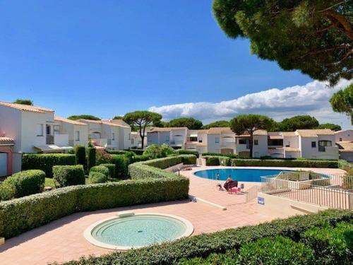 une cour avec une piscine et certaines maisons dans l'établissement T2 RENOVE, CLIM, WI-FI, PISCINE, TENNIS, PARKING PRIVÉ À 100M PLAGE ROQUILLE - FR-1-607-20, au Cap d'Agde