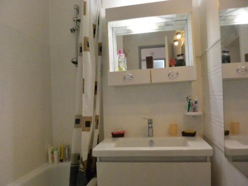 une salle de bain avec un lavabo, un miroir et une baignoire dans l'établissement Villa T3 avec piscine, proche plage et golf - Cap d'Agde - FR-1-607-49, au Cap d'Agde