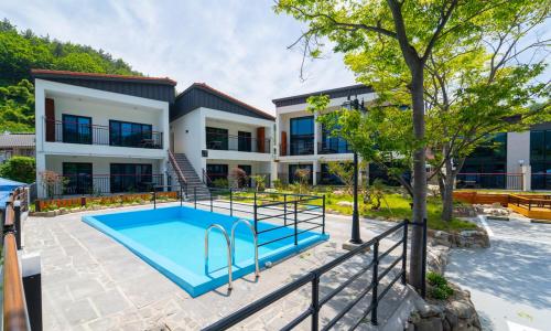 una vista exterior de una casa con piscina en Seolli Resort Pension, en Namhae