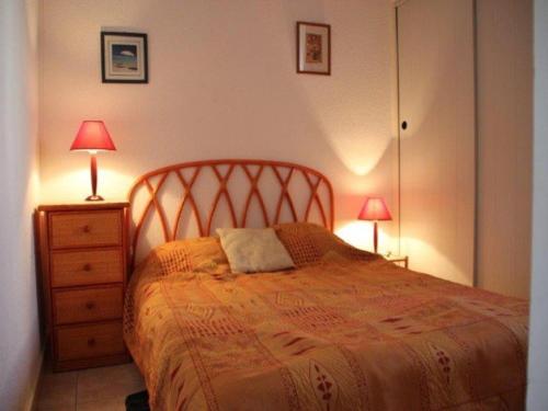 - une chambre avec un lit et une commode avec deux lampes dans l'établissement Villa cosy climatisée, 10 min plage, piscine, parking privé - FR-1-607-87, au Cap d'Agde