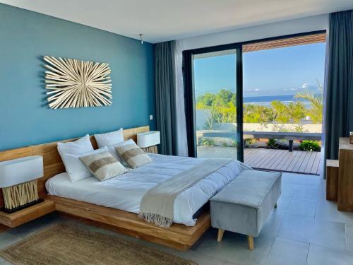 um quarto com uma cama grande e uma parede azul em Villa Des Sens em Ruisseau Créole