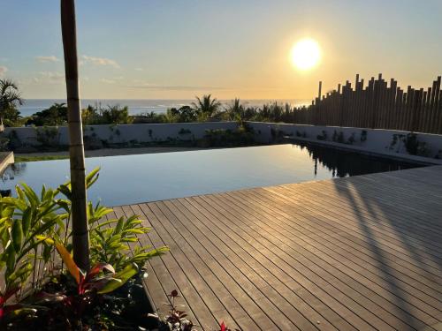 - une piscine avec vue sur le coucher du soleil en arrière-plan dans l'établissement Villa Des Sens, à Ruisseau Créole