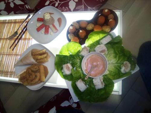 a table topped with a plate of food with salad and dips at Il Daviduccio Suite in Siracusa