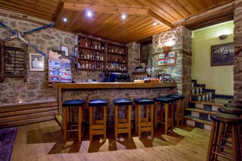 a bar with blue stools in a room at Pigi Tarlampa Hotel in Ano Trikala