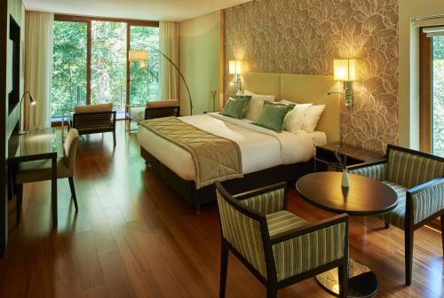 a hotel room with a bed and a table and chairs at Mercure Iguazu Hotel Iru in Puerto Iguazú