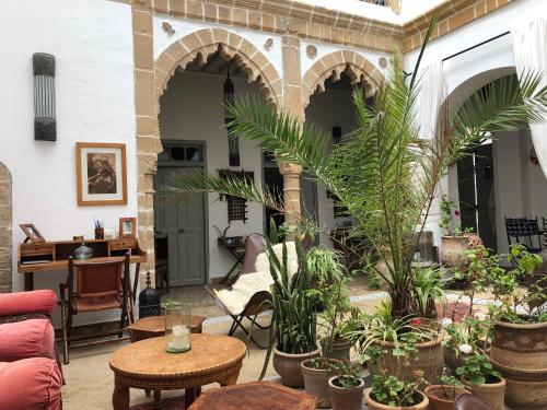 a patio with a bunch of plants and tables at Riad le Consulat - Riad privé avec services in Essaouira