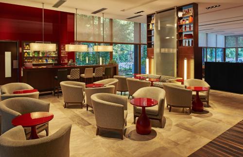 a restaurant with chairs and tables and a bar at Mercure Iguazu Hotel Iru in Puerto Iguazú