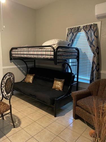 1 dormitorio con litera, sofá y silla en Downtown Heaven, en San Antonio