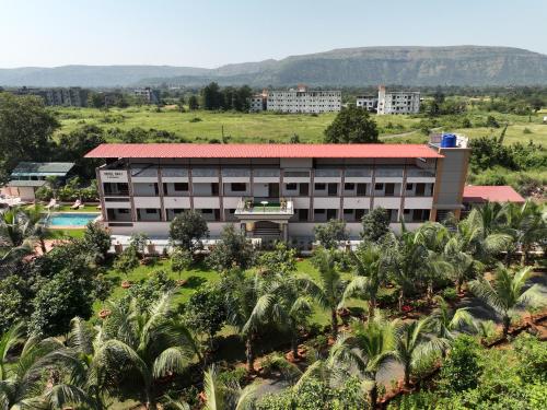 einen Blick über ein Gebäude mit Palmen in der Unterkunft Raaj Resort in Panvel