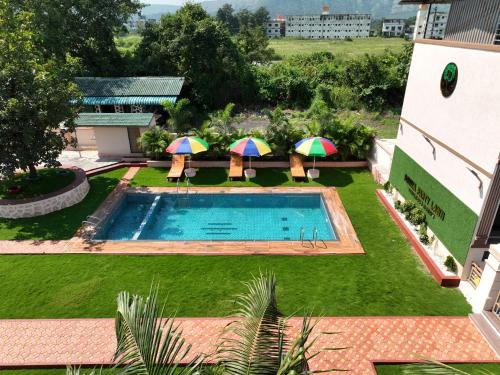 una vista aérea de una piscina con sillas y sombrillas en Raaj Resort, en Panvel