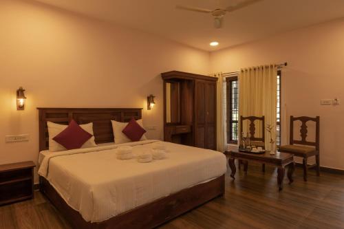 a bedroom with a large bed and a chair at Avadale Thekkady - Stag Groups Not Allowed in Thekkady