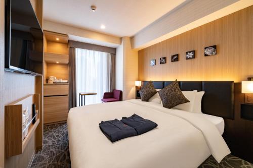 a hotel room with a large bed and a television at Hotel Shuranza MAKUHARI BAY in Chiba