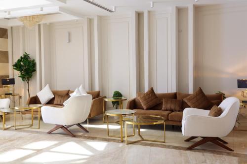 a living room with a couch and chairs and tables at Abraj INN Royal Hotel فندق أبراج إن الملكي in Doha