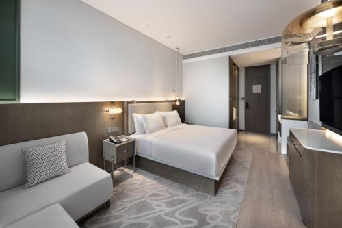 a hotel room with a bed and a couch at The Barony Jinan East in Jinan