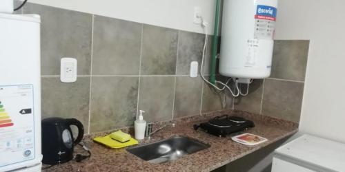 encimera de cocina con fregadero y microondas en Departamento DYD JUJUY en San Rafael