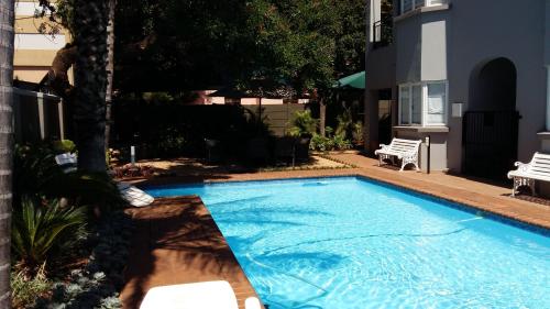 a swimming pool in the yard of a house at Liza's Cottage Guesthouse in Pretoria