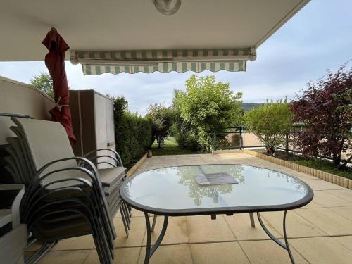 une table et des chaises en verre sur la terrasse dans l'établissement Appartement cosy avec terrasse et garage à deux pas des pistes ! - FR-1-548-24, à Villard-de-Lans