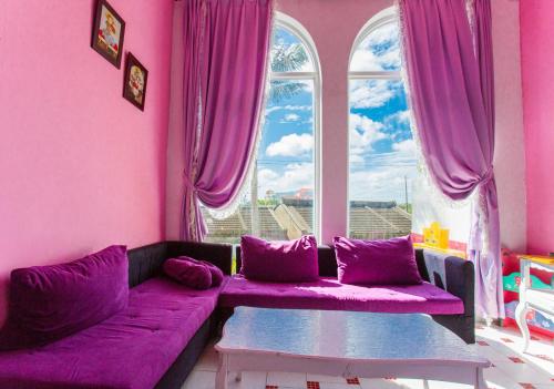 a purple living room with a purple couch and a window at 墾丁戀戀莎堡特色民宿 Castillo in Eluan