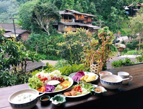 a table topped with plates of food on a table at Preanhuan Homestay in Mae On