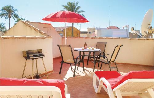 eine Terrasse mit Tisch und Stühlen und einem Sonnenschirm in der Unterkunft Cozy Apartment In Los Alcazares in Los Alcázares