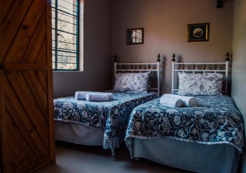 ブルームフォンテーンにあるFarm stay at Lavender Cottage on Haldon Estateのベッドルーム1室(ベッド2台、窓付)