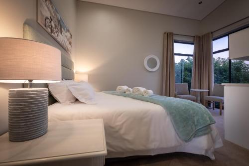 a bedroom with a bed and a table with a lamp at Anchor's Haven Hersham in Groot Brak Rivier