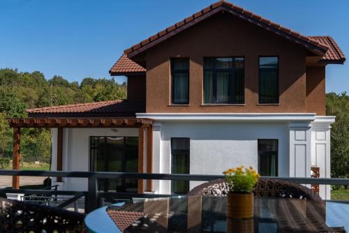a house with a balcony with a table at Shabran Wellbeing Resort in Pirǝbǝdil