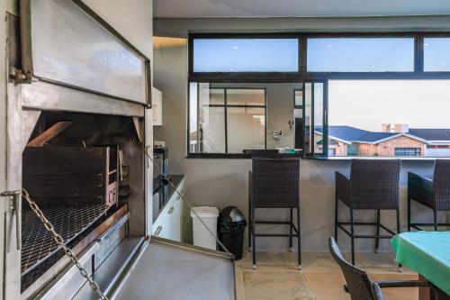 a kitchen with a pizza oven and a table at Anchor's Haven Hersham in Groot Brak Rivier