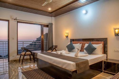 - une chambre avec un grand lit et un balcon dans l'établissement Aravindam House I Open Rooftop & Garden I Bonfire I By Vanasthali Kasauli, à Kasauli