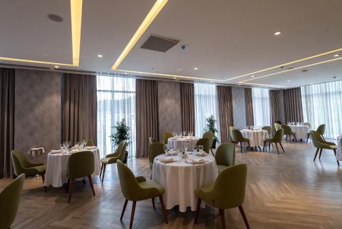 a dining room with tables and chairs and windows at Shabran Wellbeing Resort in Pirǝbǝdil